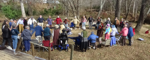 35 Friends stand in a circle holding hands outside the former Swannanoa Friends meetinghouse.